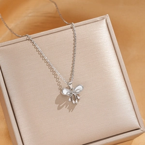 Detailed close-up of bowknot pendant necklace with zircon stones on a jewelry box