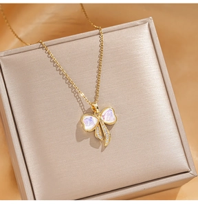 Close-up of golden bow pendant with iridescent inlay and sparkling zircon details