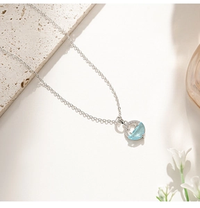 Detailed macro of cat-eye stone planet pendant on a silver titanium steel necklace