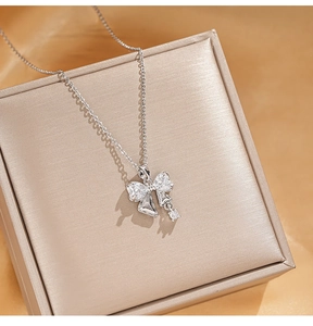 Detailed close-up of a silver bow necklace with zircon crystals on a luxury display box