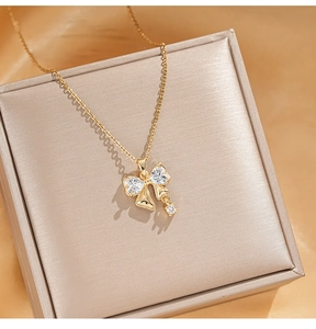 Detailed macro view of a gold bow pendant necklace with zircons on a jewelry box