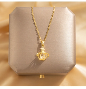 Detailed close-up of golden planet pendant with star detail on elegant silk background