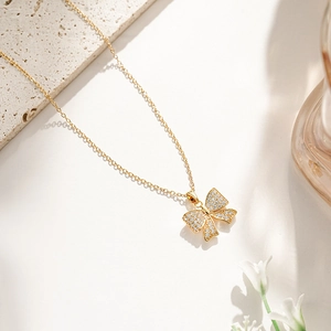 Close-up of golden bow pendant necklace with shimmering cubic zirconia inlay details