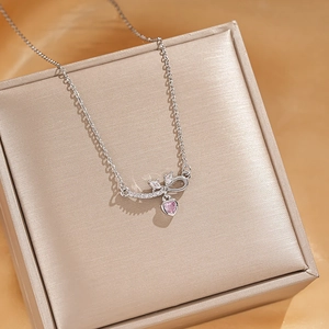 Sparkling zircon bow necklace with pink heart pendant on a silk jewelry gift box