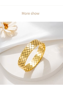 Dettaglio del bracciale dorato con motivo a rombi su un supporto bianco raffinato
