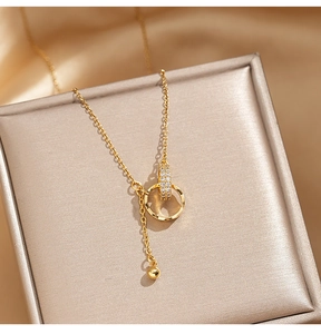 Makro-Detail der goldenen Doppelring-Halskette mit Zirkonia auf Champagner-Samt-Schmuckbox