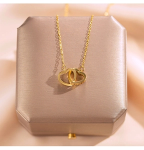 Detail der doppelten Herz-Halskette in Gold mit Zirkonia-Einlage auf Schmuckschatulle