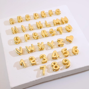 Macro detail of 18K gold plated letter and number beads for DIY jewelry making