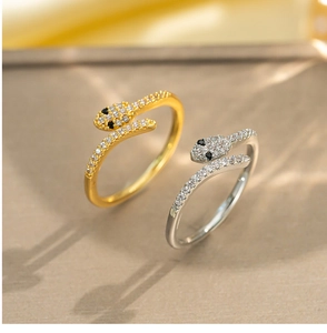 Macro shot of silver and gold snake rings with pave-set cubic zirconia and black eyes
