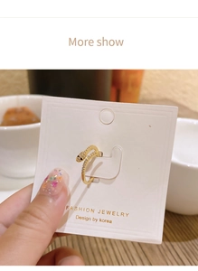 Macro shot of gold snake ring with white cubic zirconia pavé on jewelry card display