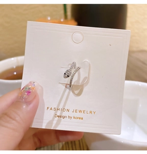 Detailed view of silver snake ring with pavé zircons on a white jewelry display card