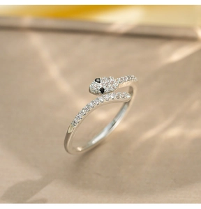 Macro shot of silver snake ring with pavé-set zircons and black gemstone eyes