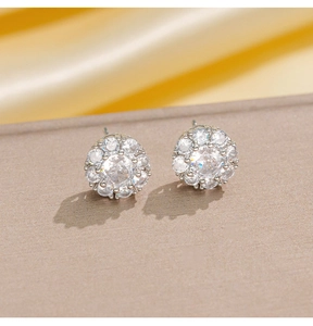 Primer plano macro de pendientes de plata con diseño de flor y circonitas brillantes