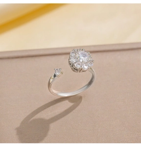 Primer plano de un anillo ajustable plateado con un racimo de flores de circonita blanca