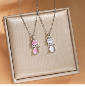 Détail macro de colliers chat avec pendentifs en pierre d'oeil de chat rose et blanc argent