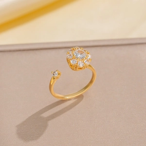 Elegante anillo de titanio dorado con diseño de flor de circón en fondo de seda