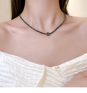 Detailweergave van de titanium choker met zilveren kralen en een geometrische hanger