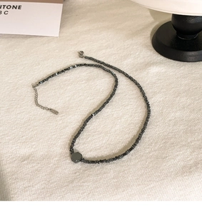 Detail van de kralenketting van staal met een zeshoekige hanger en een karabijnsluiting
