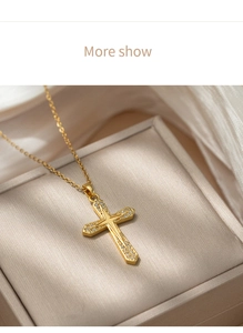 Close-up of golden titanium steel cross necklace with inlaid crystals in a gift box