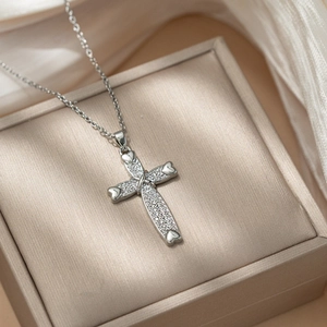 Polished titanium steel cross necklace with heart-shaped ends and shimmering pavé zircons