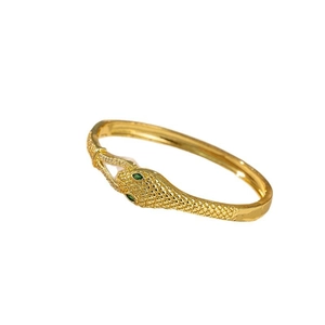 Eleganter Schlangen-Armreif in Gold mit grünen Edelsteinaugen und funkelnden Zirkonia-Akzenten