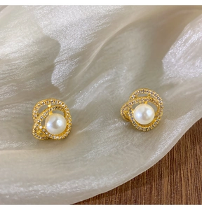 Détail macro de boucles d'oreilles camélia en perles avec incrustation de zircons brillants