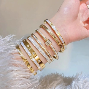 Set aus goldfarbenen Titanstahl-Armbändern mit römischen Ziffern und Kristallbesatz