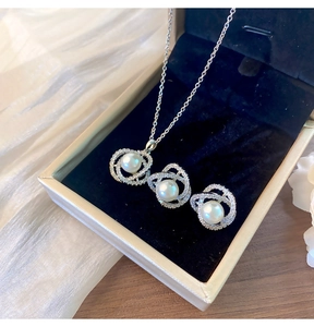 Gros plan d'un ensemble de bijoux camélia en argent avec perles blanches et zircons