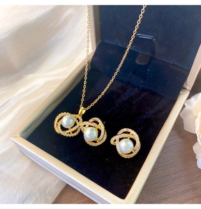 Détail d'une parure de bijoux en perles de camélia comprenant collier et boucles dorés