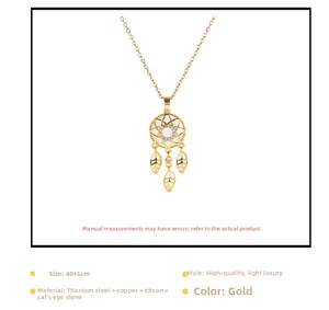 Detailed view of golden dreamcatcher pendant with opal stone and hanging leaf charms