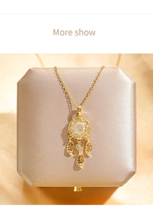 Detailed close-up of golden dreamcatcher necklace with opal and zircons in a jewelry box