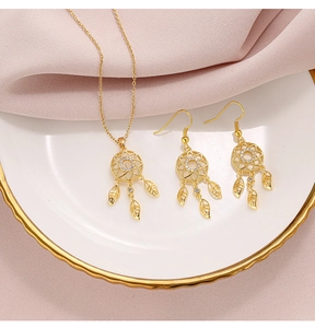 Macro view of gold dreamcatcher jewelry set with opal and leaf charms on silk