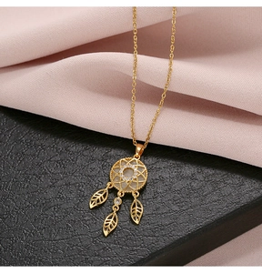 Macro shot of gold dreamcatcher pendant with opal center and zircon stones on a chain