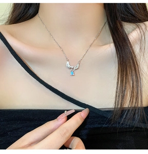 Detail of angel wing pendant with blue water drop moonstone on minimalist silver chain