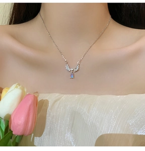 Detailed close-up of a moonstone angel wing pendant necklace worn on a woman's neck