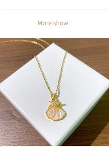 Détail du collier pendentif étoile de mer et coquillage doré orné de zircons brillants