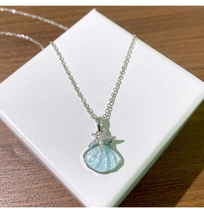 Gros plan du pendentif coquillage avec étoile de mer en zircon sur collier en titane