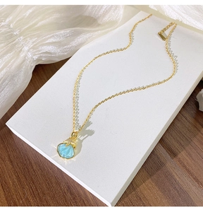 Détail du collier en titane doré avec pendentif coquillage bleu et étoile de mer en zircon