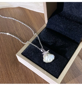 Gros plan du collier en titane avec pendentif en coquillage, étoile de mer et zircons