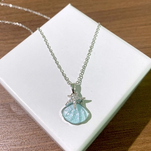 Collier en acier titane avec pendentif coquillage bleu et étoile de mer en zircon