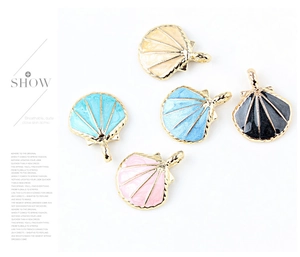 Detalle de dijes de conchas coloridas con base de aleación dorada para joyería artesanal