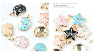 Detalle macro de colgantes de estrella de mar y concha coloridos con bordes dorados y esmalte
