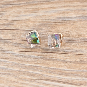 Detail macro view of square cut aurora crystal studs with multifaceted color reflections