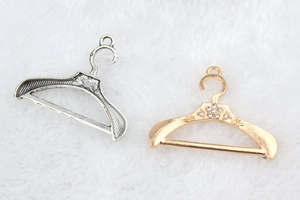 Dettaglio di ciondoli a forma di gruccia fai-da-te in argento antico e oro con strass