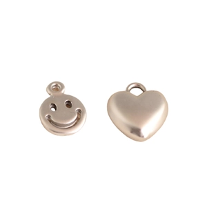 DIY jewelry set featuring polished golden heart and hollow smiley face charm pendants