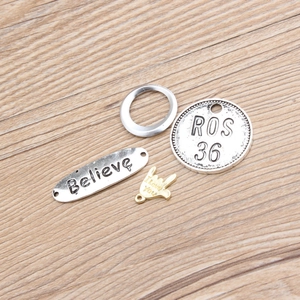 DIY jewelry charm set with engraved Believe and I love you pendants on wood surface