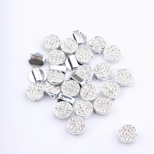 Macro detail of silver plated alloy circular sliders with sparkling rhinestones for DIY crafts