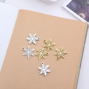 Goldene und silberne Schneeflocken-Anhänger für DIY-Schmuck auf Kraftpapier-Hintergrund