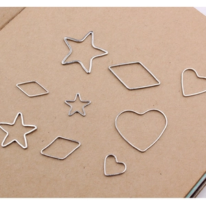 Flat lay of assorted geometric hollow metal charms in heart and star shapes for DIY jewelry
