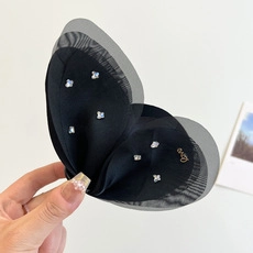 Detailed view of the mesh butterfly hair clip with silver rhinestones and Love letter logo